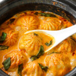 Soup dumplings in thai red curry sauce