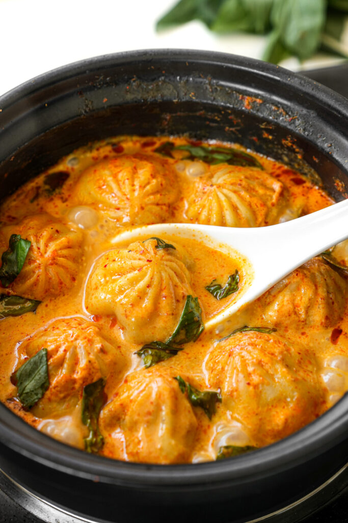 Soup dumplings in thai red curry sauce