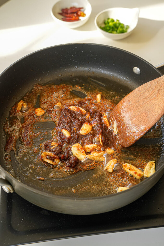 stir fry aromatics garlic and sacha sauce together 