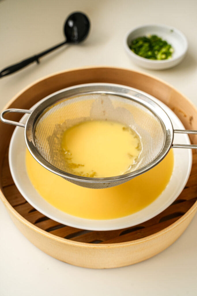 strain the egg mixture for Chinese steamed eggs