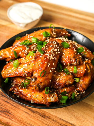 air fryer sweet and sour chicken wings garnished with green onions and sesame seeds