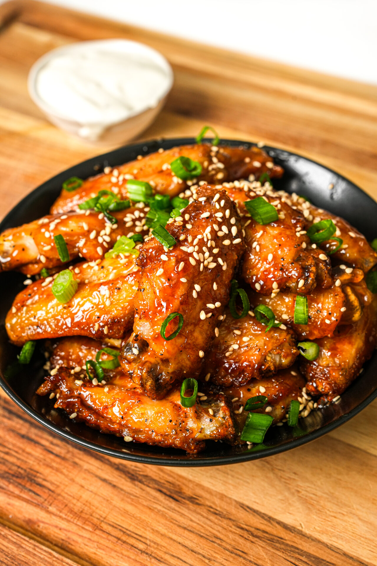 air fryer sweet and sour chicken wings garnished with green onions and sesame seeds