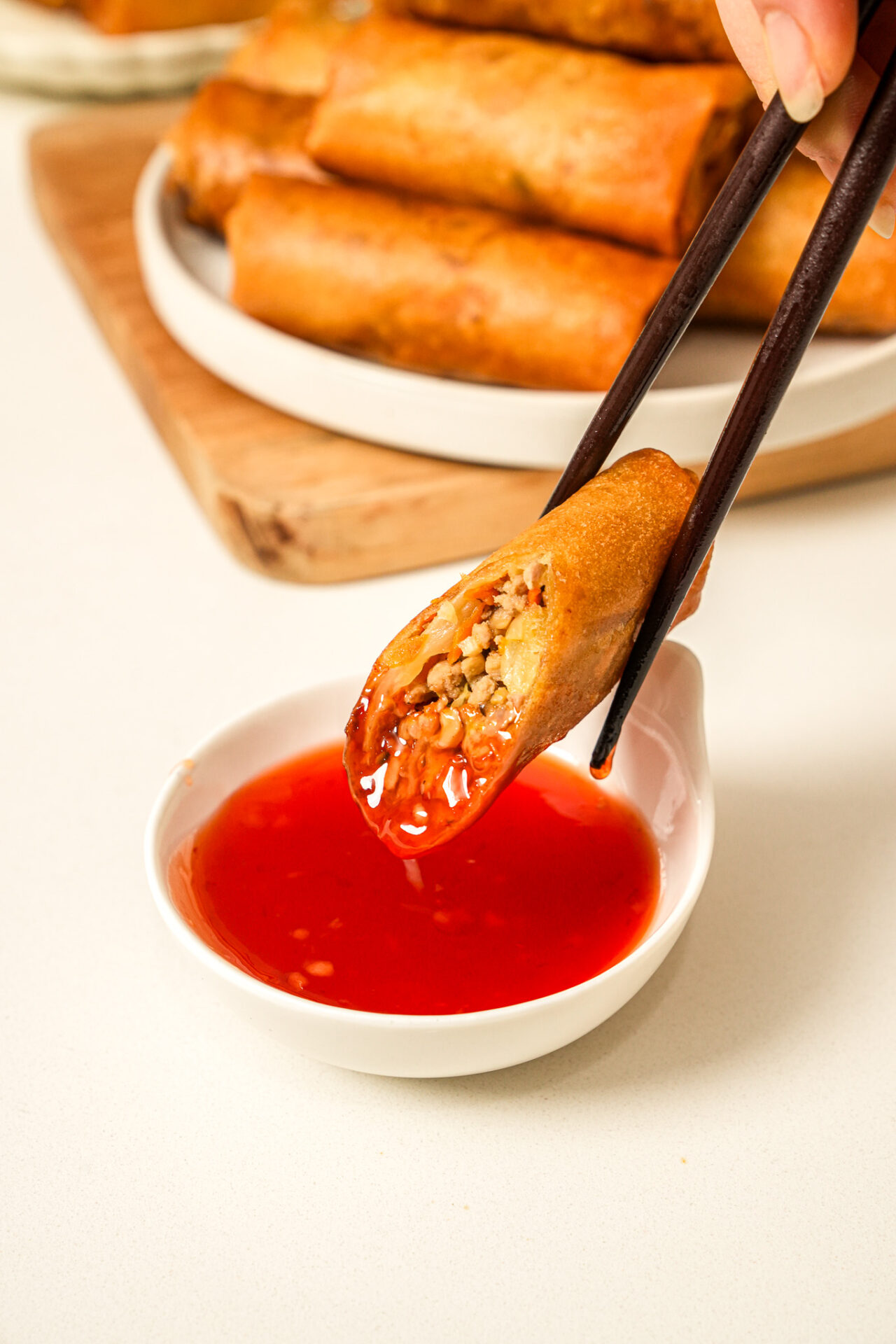 Crispy Pork and Cabbage Egg Rolls dipped in sweet chilli sauce